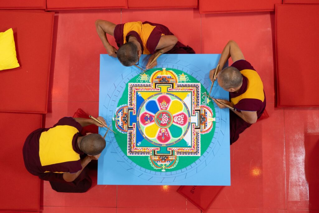 Tibetische Mönche streuen Sandmandala