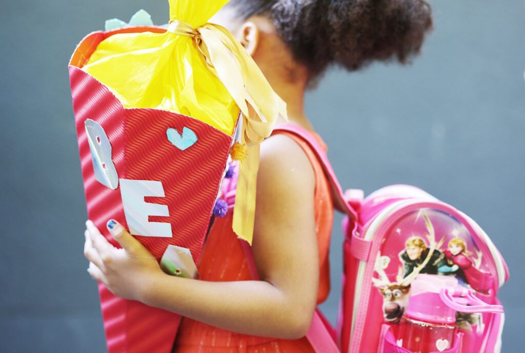 Ein Kind hält bei der Einschulung eine Schultüte im Arm