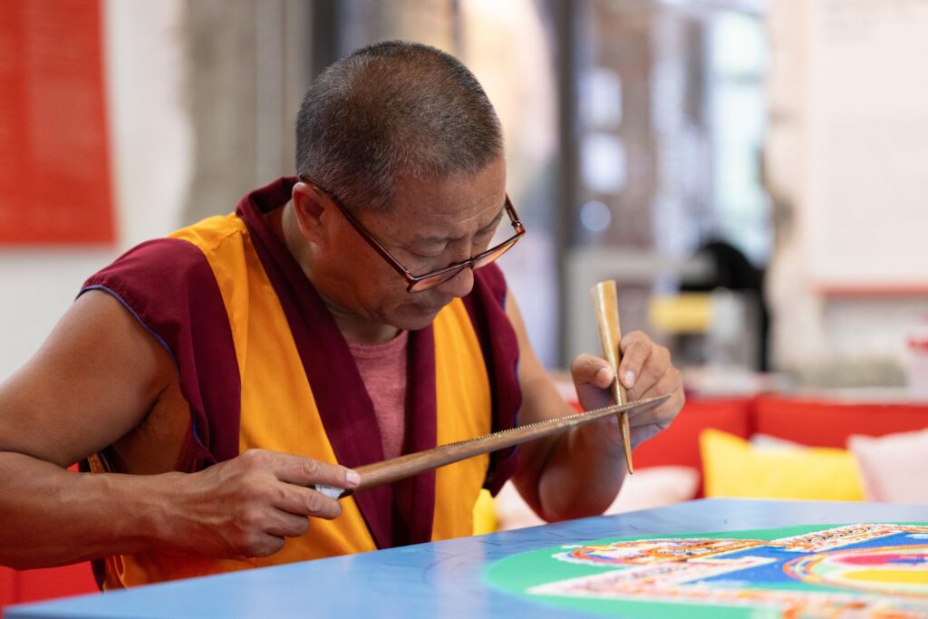 Tibetische Mönche streuen Sandmandala