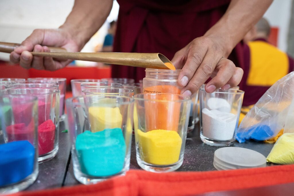 Tibetische Mönche streuen Sandmandala