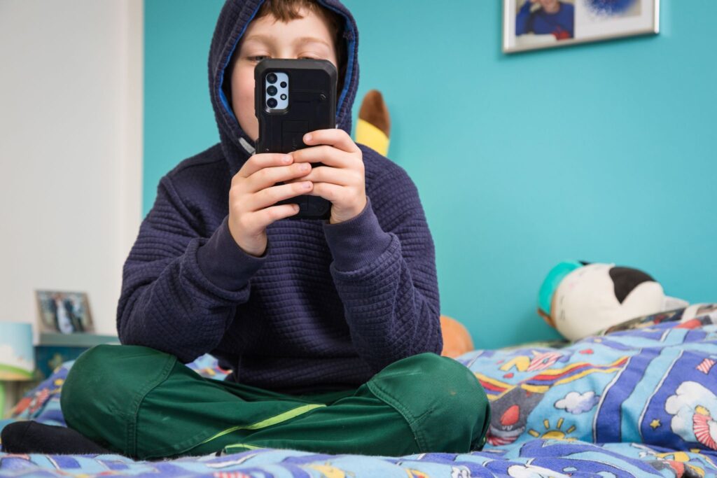 Kind hält Smartphone in den Händen