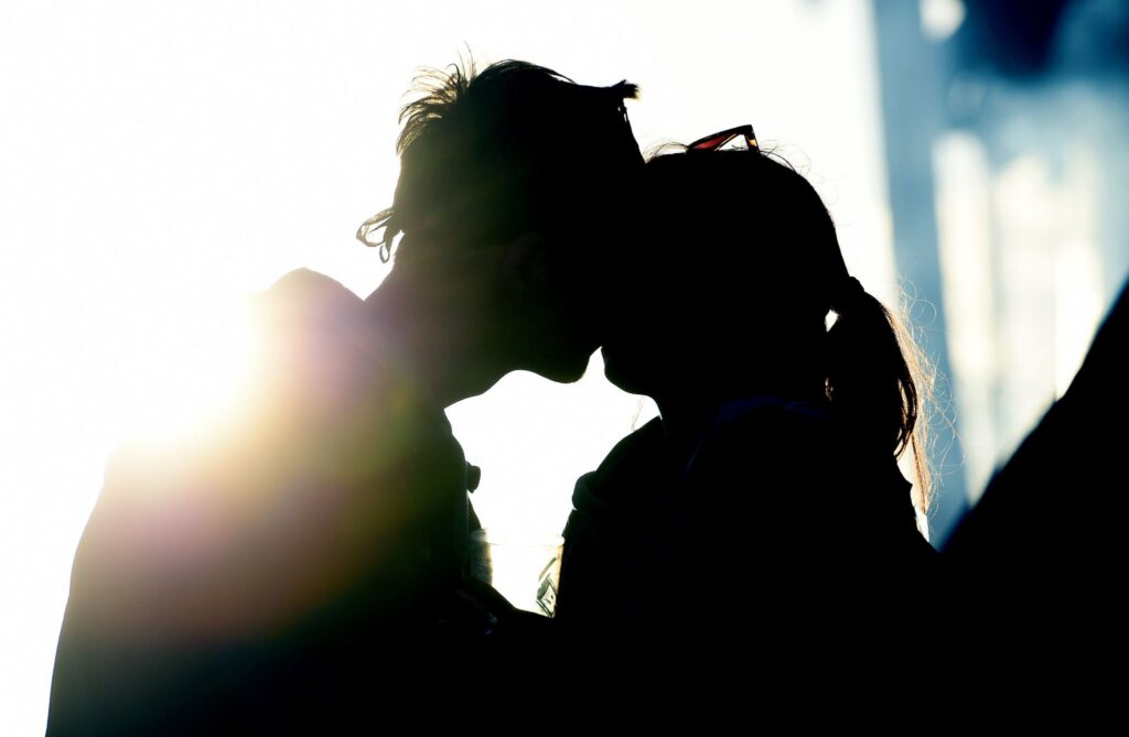 Junges Pärchen küsst sich im Licht des Sonnenuntergangs