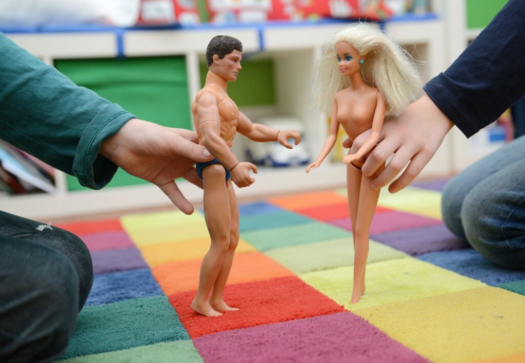 Kinder spielen mit nackten Puppen