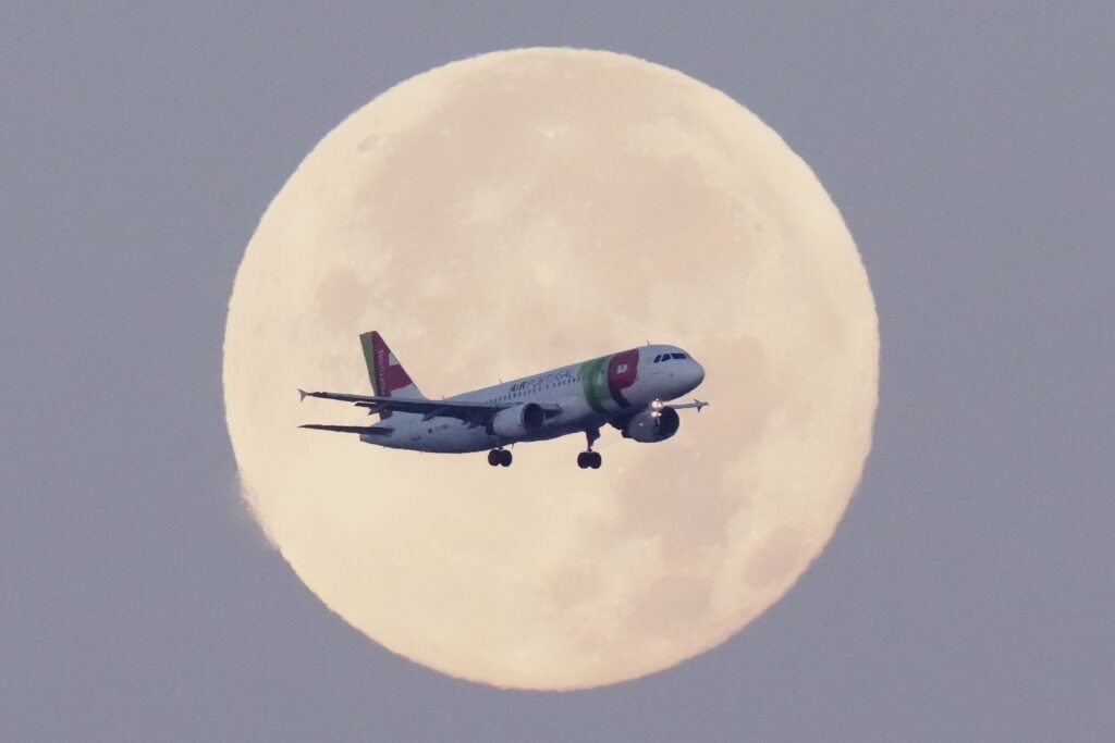 Flugzeug vor Mond