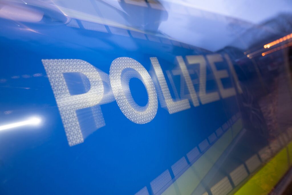 Polizei steht auf der Karosserie eines Polizeifahrzeugs